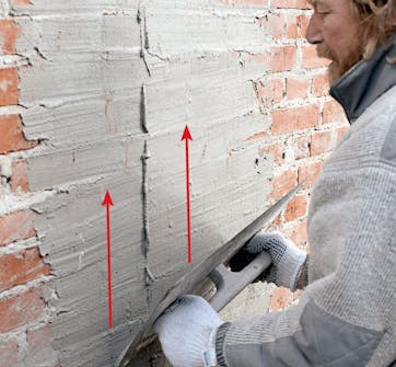 Tiiliseinän rappaus: Rappaus levitetään seinään teräslastalla Tiiliseinän rappaus: Rappaus levitetään seinään teräslastalla